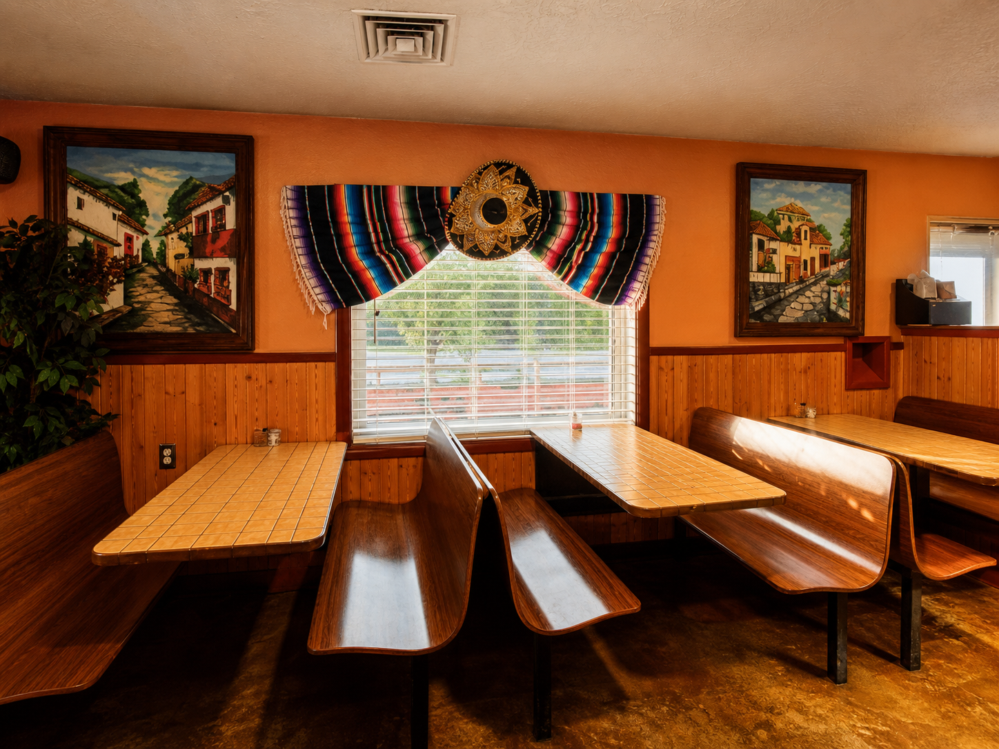 Booth seating and colorful wall decor inside La Lupita